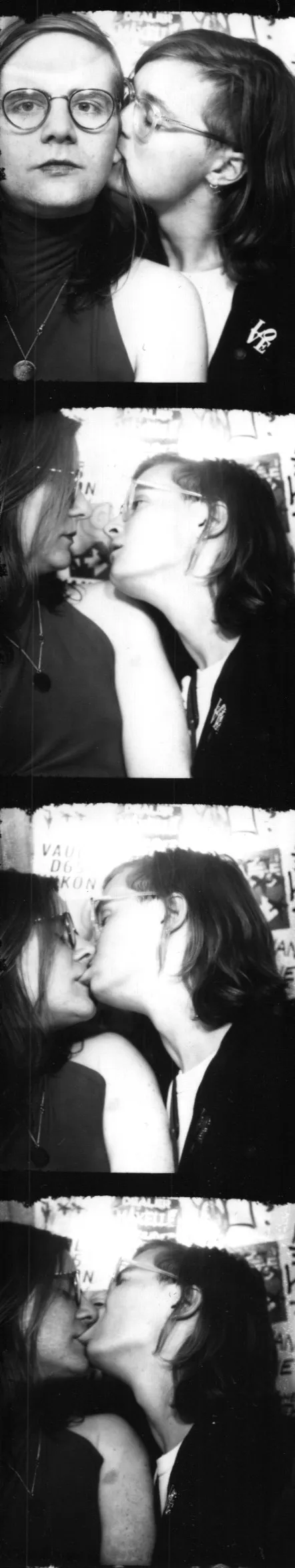 Black-and-white four-frame photobooth strip of two people kissing.